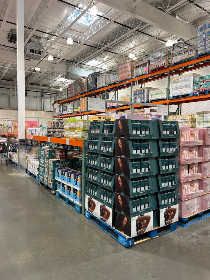 Services A spacious warehouse aisle with shelves full of health products, industrial lighting.