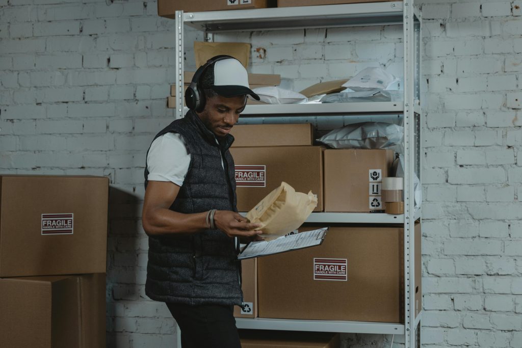 pexels photo 6170400 6170400 Warehouse worker sorting packages in an industrial environment with headphones on, focused and diligent.